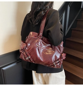 Detail view of burgundy leather tote bag with silver studs and punk biker style design