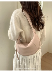 Nude pink half-moon leather shoulder bag with decorative knot strap detail
