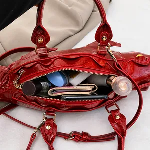 Innenansicht der roten Handtasche in Krokodilform zeigt den Stauraum für wichtige Utensilien