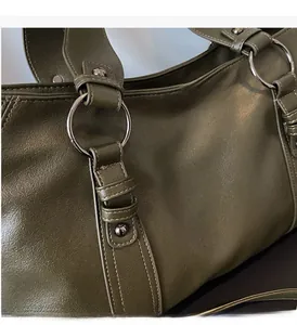 Detail of silver ring hardware and studs on dark olive green vintage leather tote bag