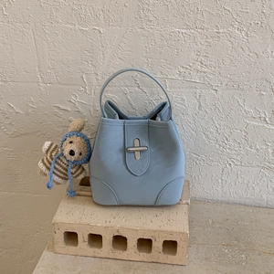 Détail du sac seau bleu clair avec fermoir argenté et charmant petit ours en peluche