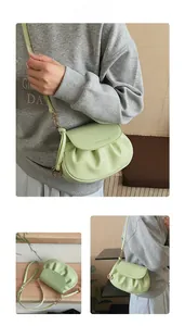Détail du sac selle plissé vert menthe avec logo élégant et ferrures métalliques