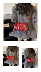 Detail of red patent leather bucket bag with silver studs and zipper accents