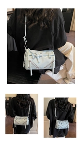 Detail of light blue soft leather crossbody bag with silver zippers and belt buckle straps