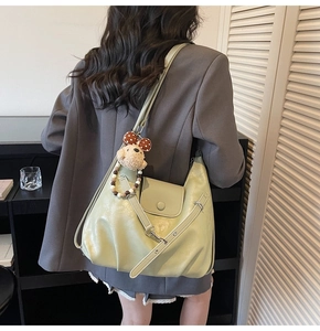 Detail der hellgrünen weichen PU-Leder Schultertasche mit Plüschbär und Perlenkette