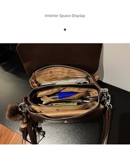 Interior space of a dark brown multi-layer shoulder bag showing compartments and lining