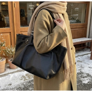 Gros plan d'un cabas en cuir noir avec boucle latérale dans un style urbain hivernal