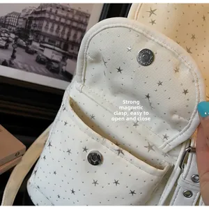 Détail du sac cabas en toile crème avec rivets étoiles et fermoir magnétique