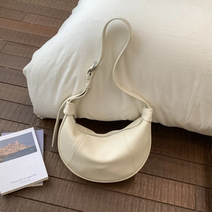 Close-up of cream crescent hobo bag with litchi texture and silver metal buckle