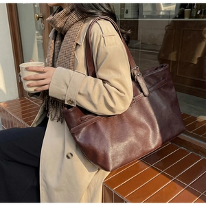 Vue détaillée d'un grand sac cabas marron en cuir avec des bretelles réglables