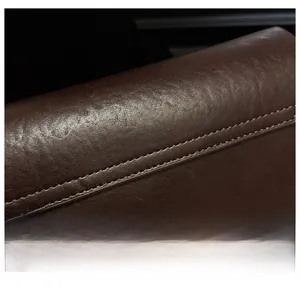 Close-up of dark brown leather crossbody bag with refined lychee grain and double stitching
