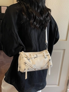 Minimalist cream white crossbody bag with decorative zippers and belt buckle accents