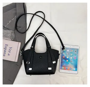 Sac seau noir comparé à un iPad, détails en cuir grainé et finitions métalliques argent