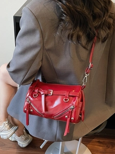 Glossy red faux leather crossbody bag with decorative buckles and silver hardware