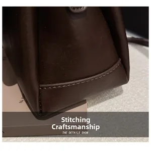 Detailed close-up of precise stitching on dark brown leather bag corner and smooth finish