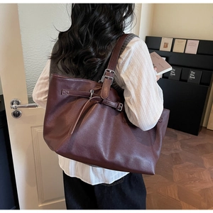 Détail du sac cabas en cuir bordeaux avec bandoulière réglable et boucles vintage