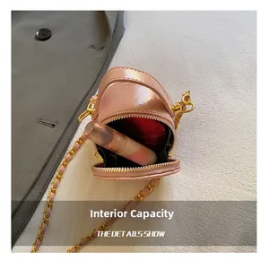 Détail de la capacité intérieure du mini sac en cuir verni rose avec un rouge à lèvres