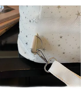 Détail de ferrures argentées et motifs d'étoiles sur le côté d'un sac à dos en toile