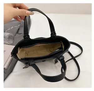Vue intérieure du sac seau noir avec doublure en tissu marron et poche zippée