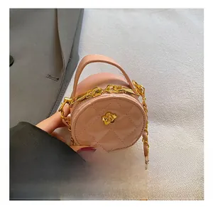 Détail du mini sac rond rose avec texture matelassée et fermoir fleur dorée élégant
