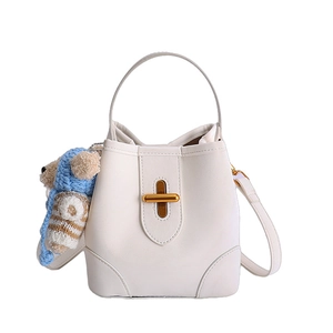 Chic beige lychee textured bucket handbag with gold twist lock and a cute bear charm