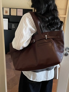 Grand sac cabas vintage marron foncé avec sangle à boucle sur un mannequin en intérieur