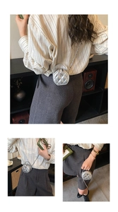 Détail d'un mini sac rond argenté matelassé avec fleur de camélia en métal et chaîne
