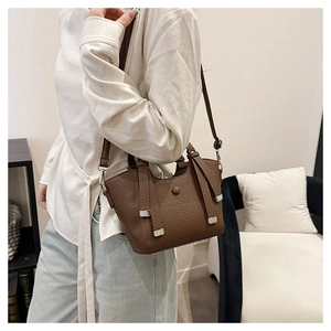 Détail du sac seau en cuir grainé marron foncé avec boucle en métal et bandoulière