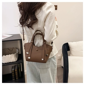 Vue détaillée du sac seau en cuir marron foncé avec grain litchi et boucles argentées