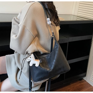 Vue détaillée du sac sous le bras noir mat avec pendentif cheval blanc décoratif