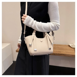 Détail du sac seau crème avec texture litchi et fine bandoulière en cuir souple