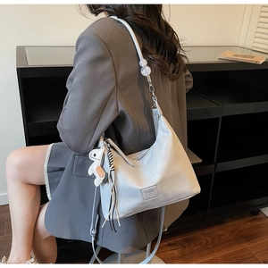 Détail du sac hobo croissant bleu clair avec perles claires et accessoire de cheval