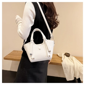 Sac seau chic couleur crème avec texture grainée porté par un mannequin en décor épuré