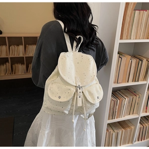Detail of star-print backpack with adjustable straps shown in a library setting