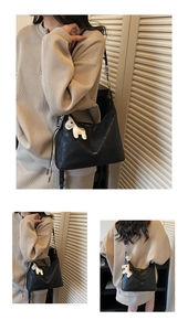 Détail du sac sous l'aisselle noir minimaliste avec texture grainée et breloque poney
