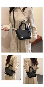 Détails d'un sac seau noir en cuir litchi avec bandoulière et finitions argentées