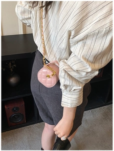 Mini sac cylindrique rose avec motif matelassé et détail de breloque camélia