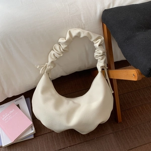 Detailansicht der beigefarbenen Halbmond-Tasche mit hochwertiger Lychee-Leder-Texturierung