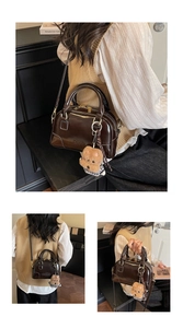 Close-up of brown glossy shell bag with gold hardware and plush dog charm detail