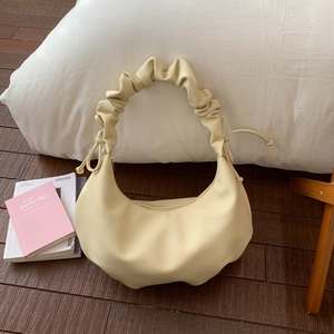 Detail einer cremefarbenen Hobo-Tasche mit Wolkenfalten-Griff und Kordelzug-Akzenten