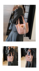 Détails du sac seau rose avec logo triangle doré et pendentif en corde tressée chic