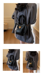 Détail du sac seau noir brillant avec logo triangulaire et breloque en corde tressée