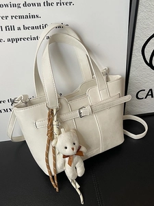 Chic cream white bucket bag with bear pendant, top handle and crossbody strap
