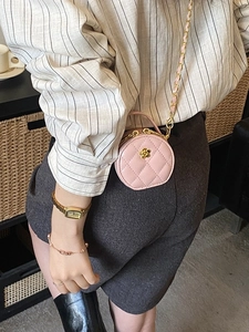 Sac bandoulière rond rose matelassé avec fermoir fleur dorée et bandoulière en chaîne