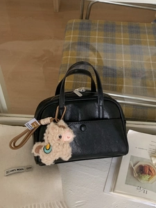 Classic black Boston handbag with matte leather finish and cute alpaca doll pendant
