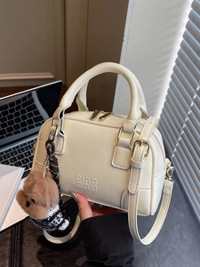 Creamy white shell-shaped Boston bag with plush bear pendant and gold hardware details