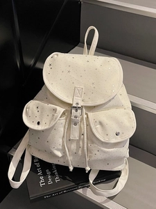 Chic beige backpack with silver star print on stone stairs for campus and commute