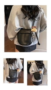 Details der schwarzen Eimer-Ledertasche mit Bärenanhänger und Perlenverzierung