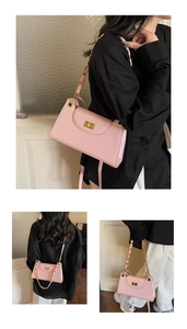 Pink crossbody flap bag with gold chain strap and turn-lock closure on model
