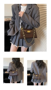 Macro detail of dark coffee textured leather bag with gold clasp and chain strap